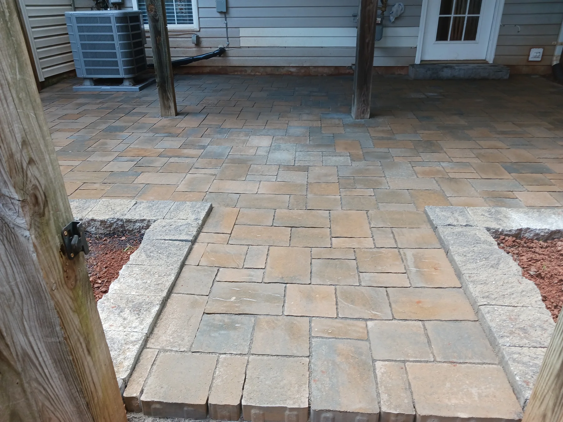 Paver patio with a contrasting border beside a home