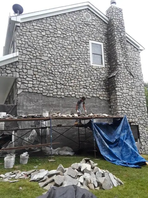 Stone-clad house exterior in progress by F. Stone Designs