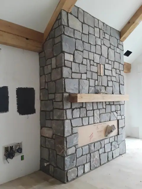 Indoor natural stone fireplace installation in progress
