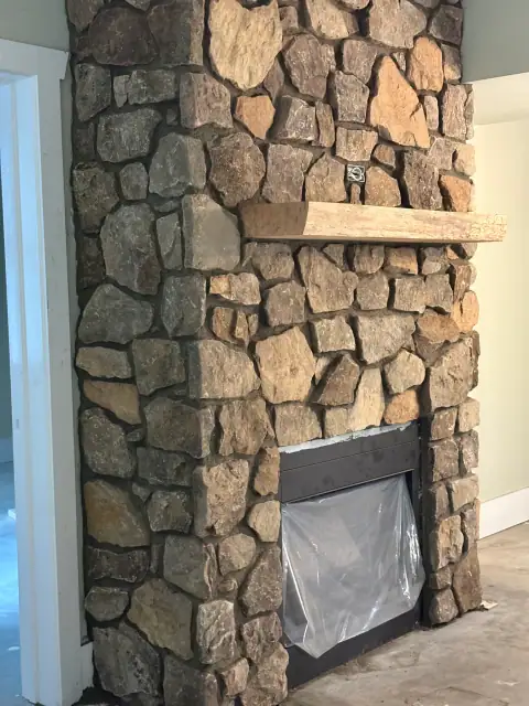 Indoor natural stone fireplace by F. Stone Designs