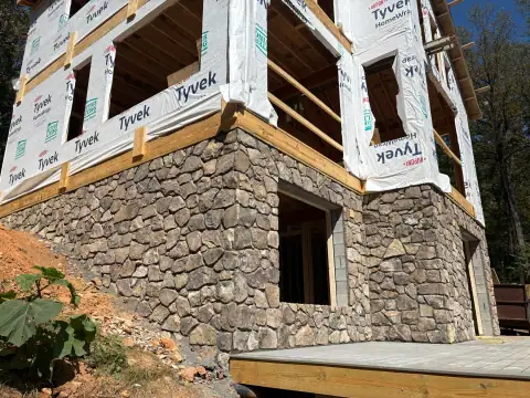 Stone-clad lower level of a house under construction