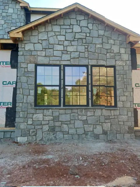 Stone-clad house front with a large window
