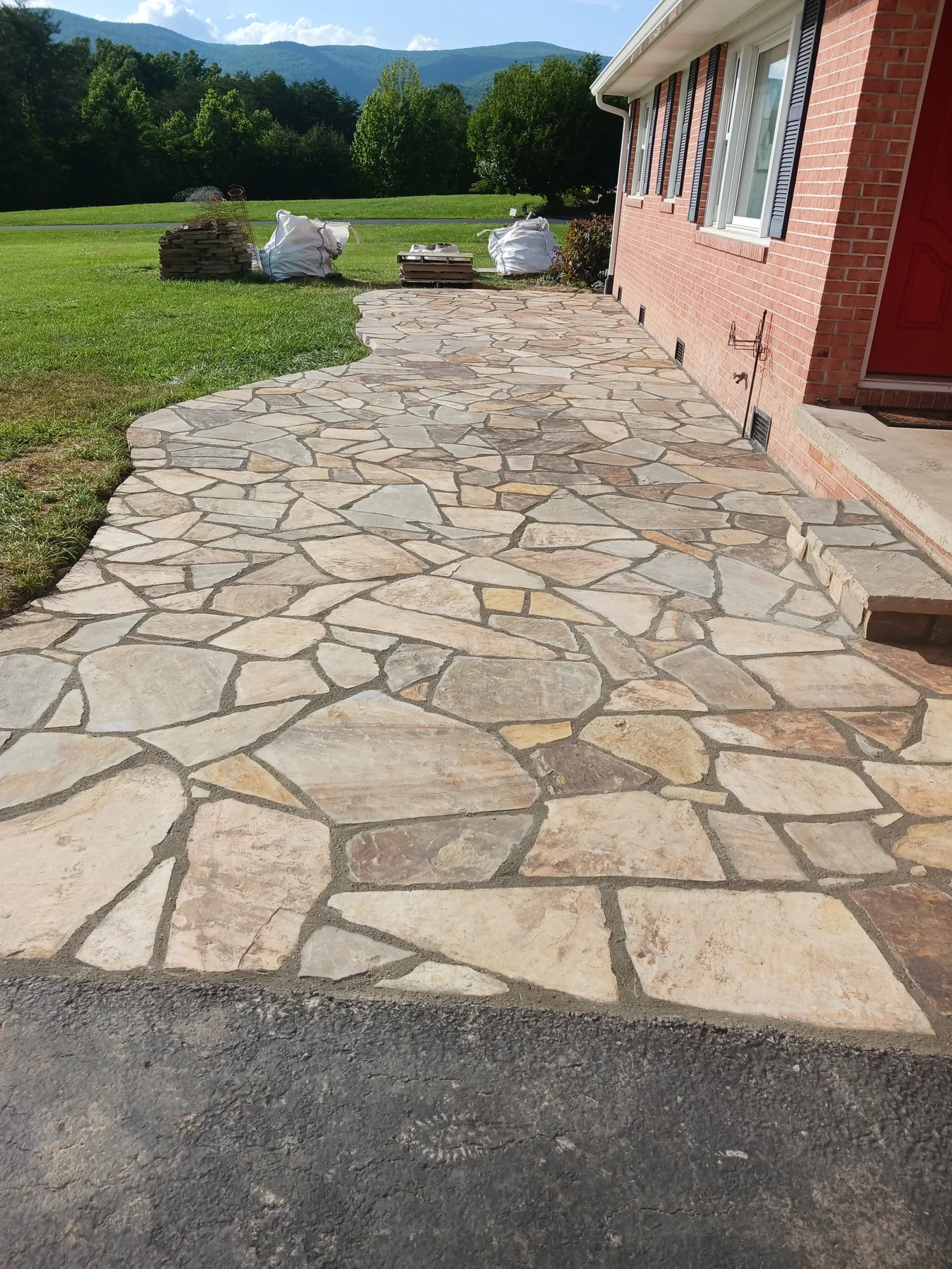 Existing flagstone patio beside a brick house