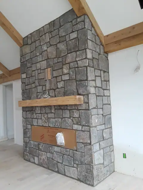 Indoor natural stone fireplace installation in progress