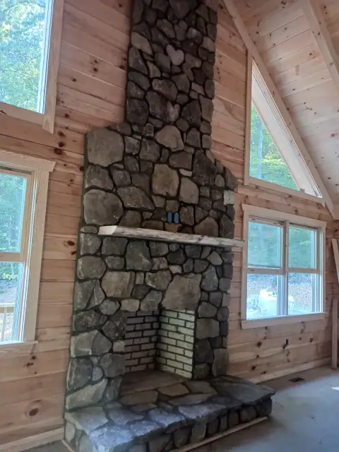 Rustic stone fireplace installation in progress