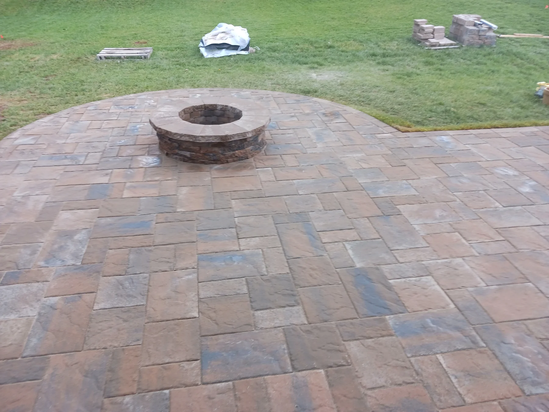 Round masonry fire pit in a paver patio